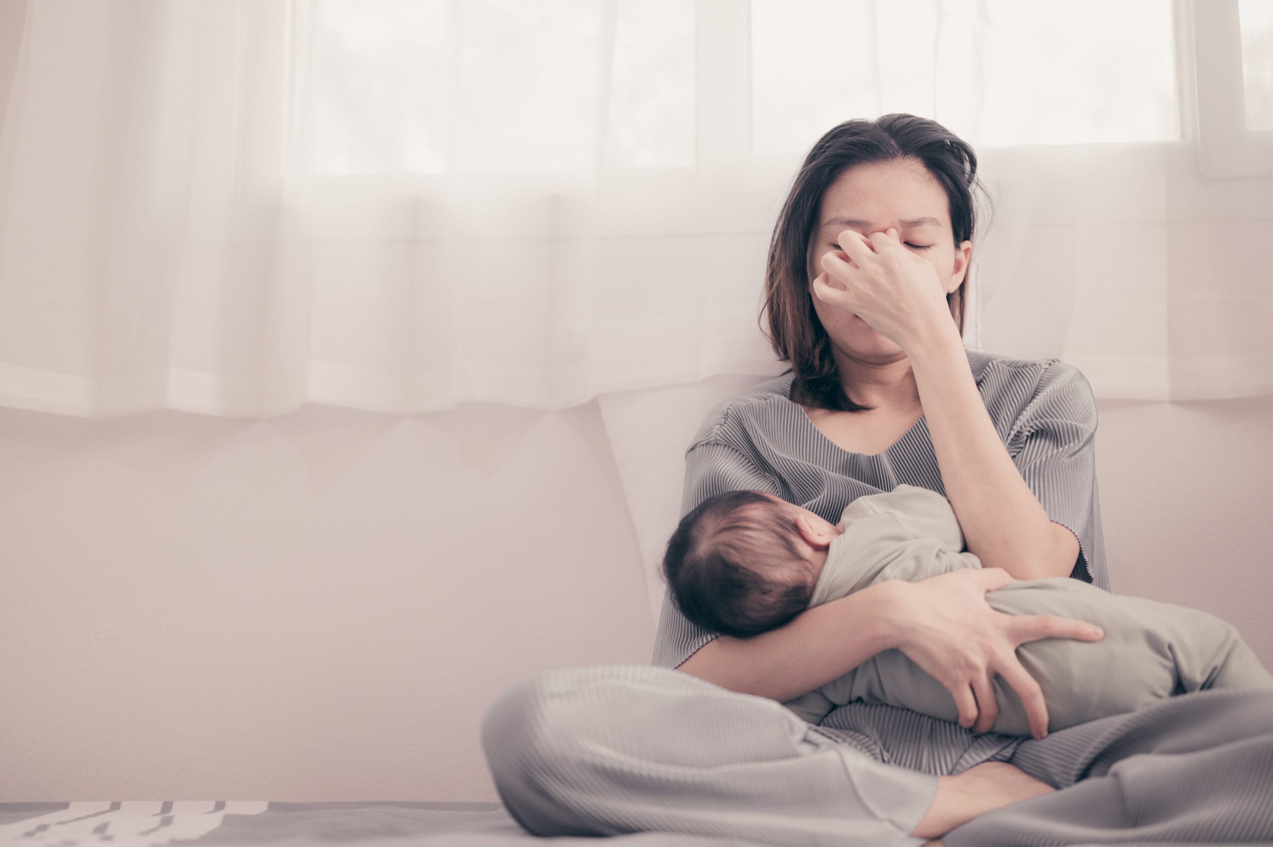 Tired Mother Suffering from experiencing postnatal depression.He birth trauma